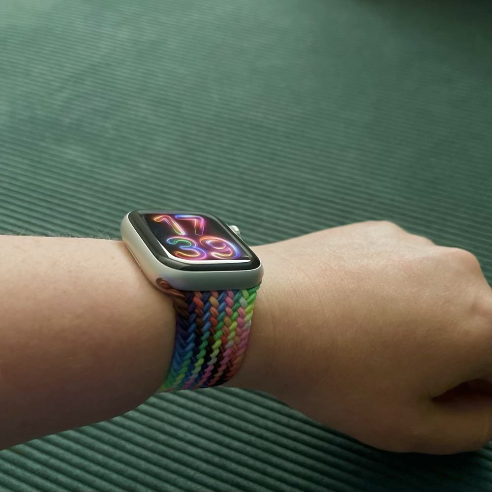 The 2024 Apple Watch pride strap and watch face, showing the interwoven neon colours